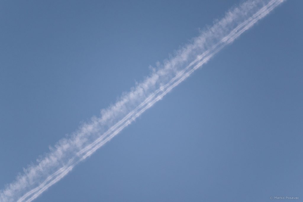 Hibridni kondenzacijski trag u obliku triju vrpci, dvije oštre nalik na cjevčice i jedna šira i oblačasta