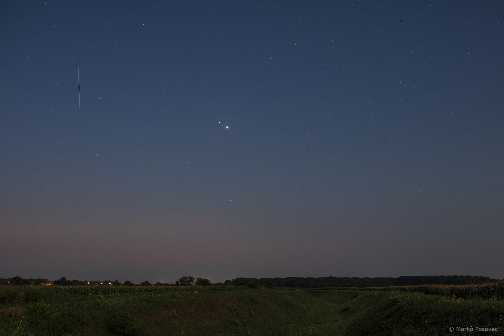 Venera i Jupiter na nebu koje se polako dani, lijevo od njih okomita je svijetla crta - meteor Perzeid
