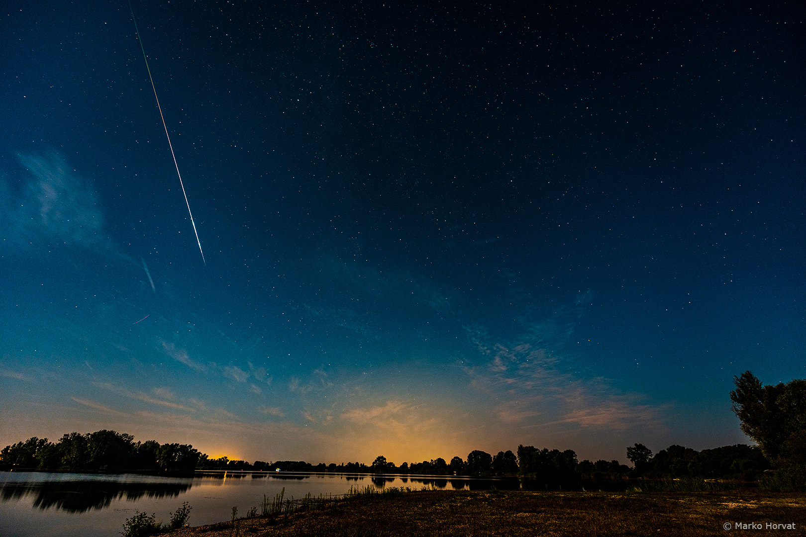 Sjajan meteor na mjesečinom obasjanom nebu iznad jezera