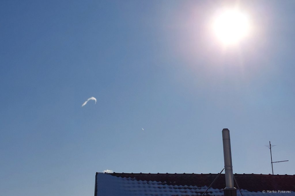 Plavo nebo iznad krova, u gornjem desnom kutu je Sunce, u sredini lijevo je mali oblačić oblika potkove