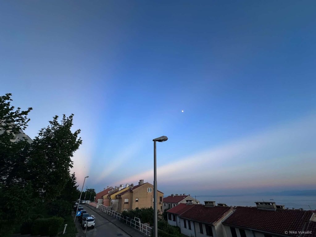 Pogled prema istoku i Mjesecu sa svijetlim i tamnim trakama preko neba